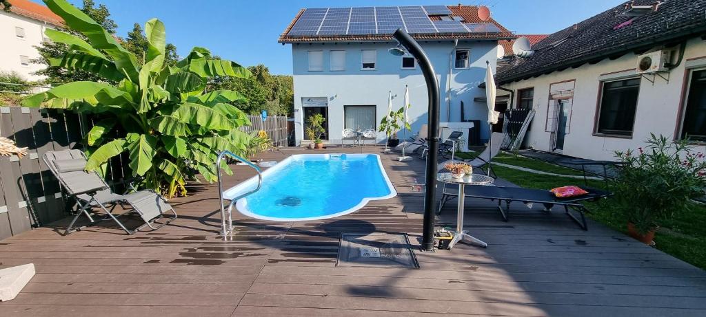 a backyard with a swimming pool and a table and a house at Apartmenthaus Wertheim in Wertheim
