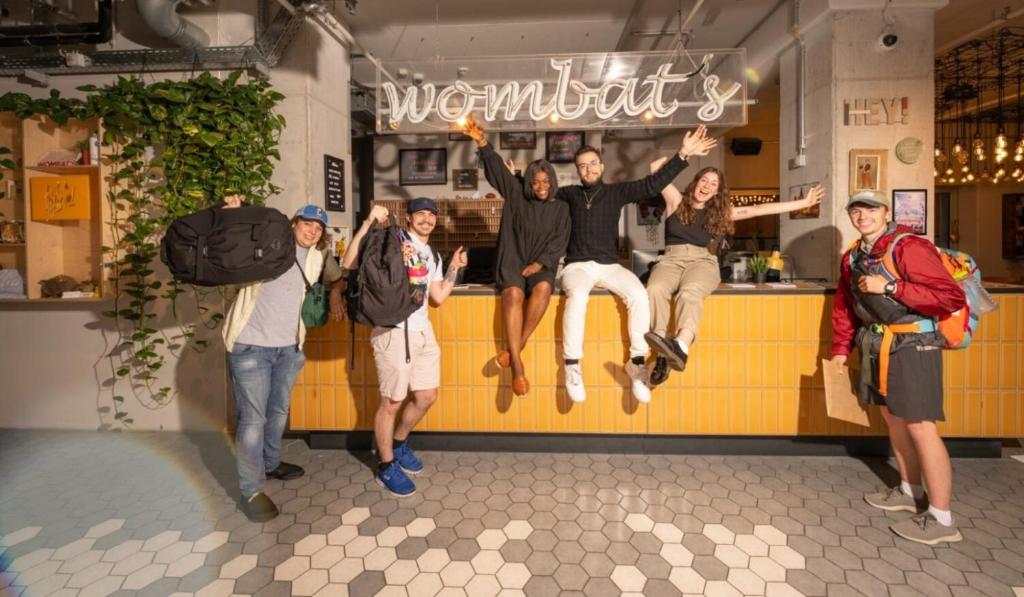 Eine Gruppe von Menschen springt vor eine Bar in der Unterkunft Wombat's City Hostel Munich Werksviertel in München