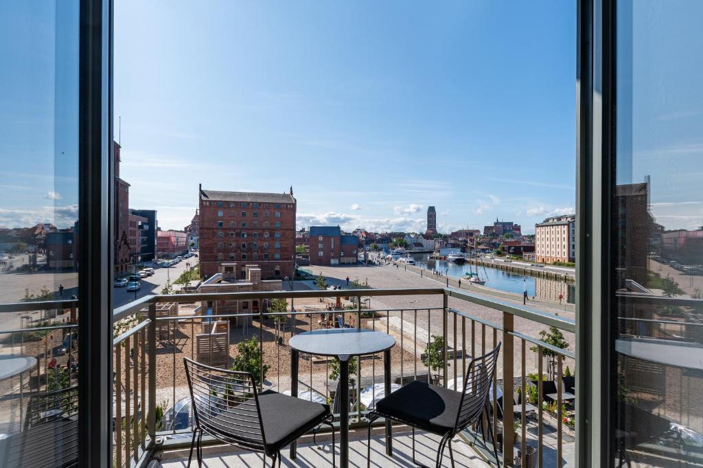 a balcony with a table and chairs and a view of a city at Ohlerich Speicher Ohlerich Speicher 2-09 in Wismar