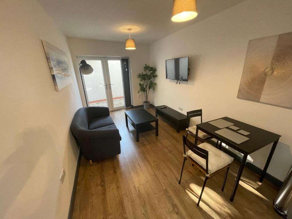 a living room with a table and a chair at Cosy 1 bedroom apartment in the centre of Bolsover in Chesterfield