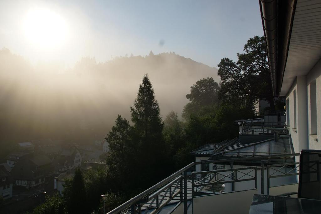 einen Blick vom Balkon eines Hauses mit einem nebligen Berg in der Unterkunft Bergpanorama - Suite Willingen in Willingen
