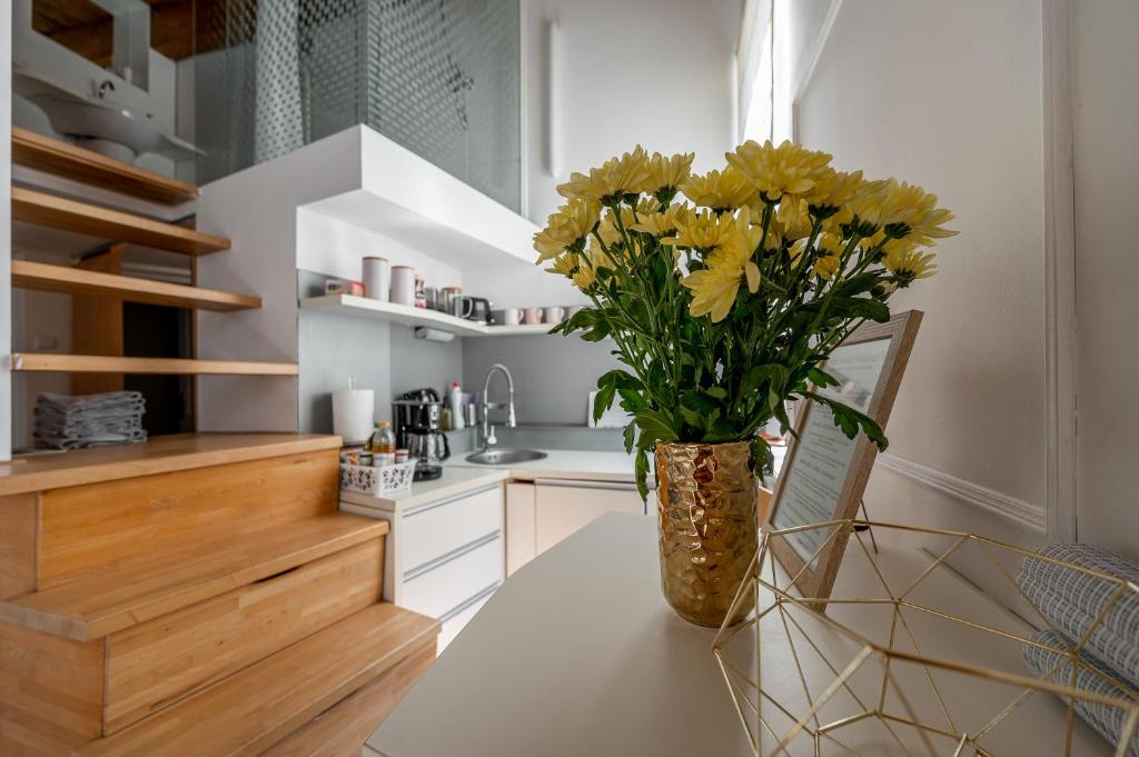 een vaas met gele bloemen op een tafel in een keuken bij Hlavna Loft Apartment Kosice in Košice