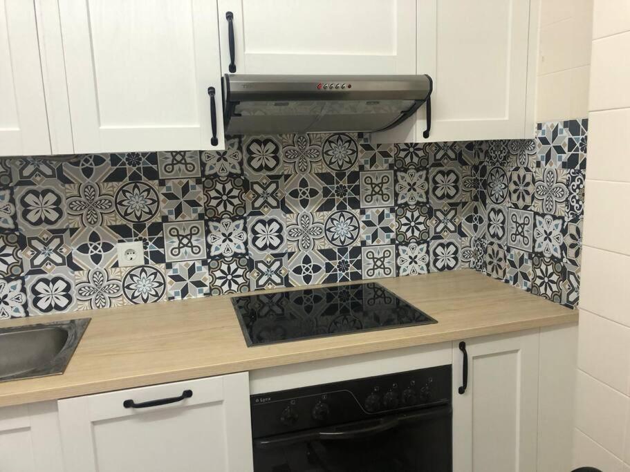a kitchen with black and white tiles on the wall at Piso los franchutes in Cabra