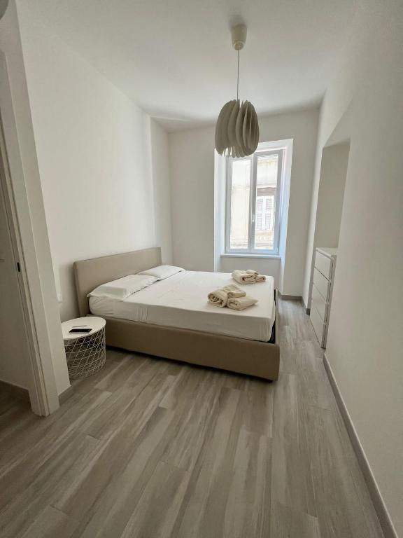 a white bedroom with a bed and a window at Luxury apartment + garage in Trieste