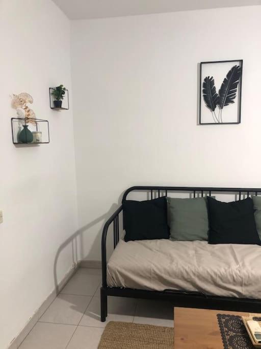 a bed in a white room with pictures on the wall at Piso los franchutes in Cabra