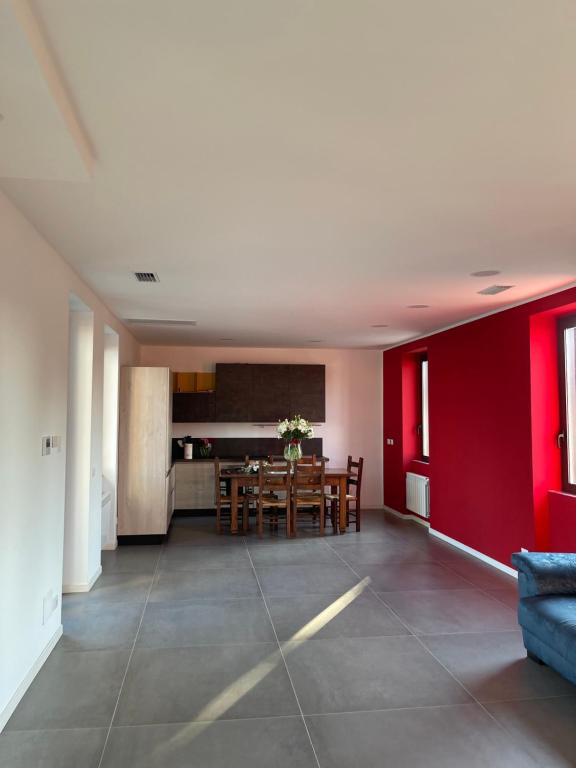 sala de estar con mesa y pared roja en GC Petit Palais, en Gallarate