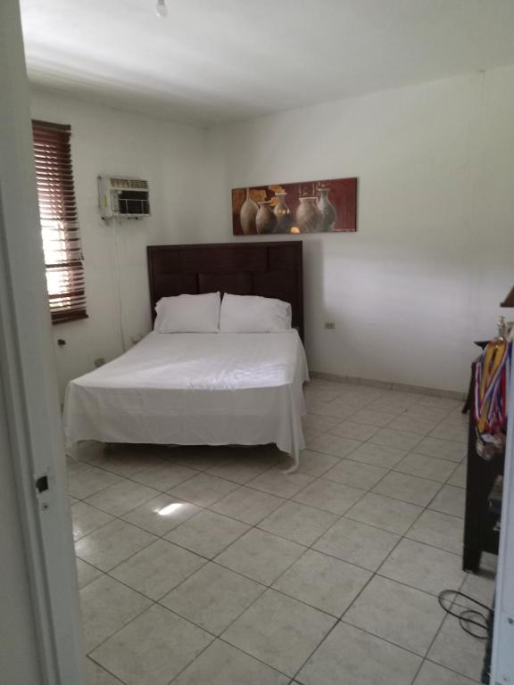 a bedroom with a white bed in a room at Heidy House in Arecibo