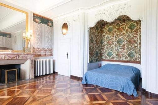 a bedroom with a blue bed and a fireplace at CHATEAU MONTALEMBERT Maîche in Maîche