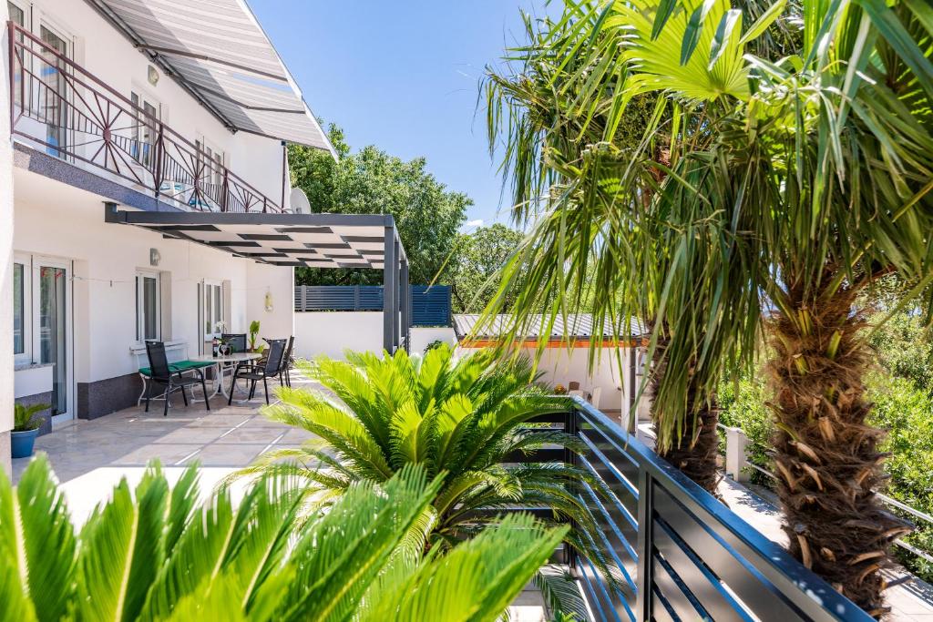 - une vue sur le patio d'une maison avec des palmiers dans l'établissement Apartmani Katica, à Povile