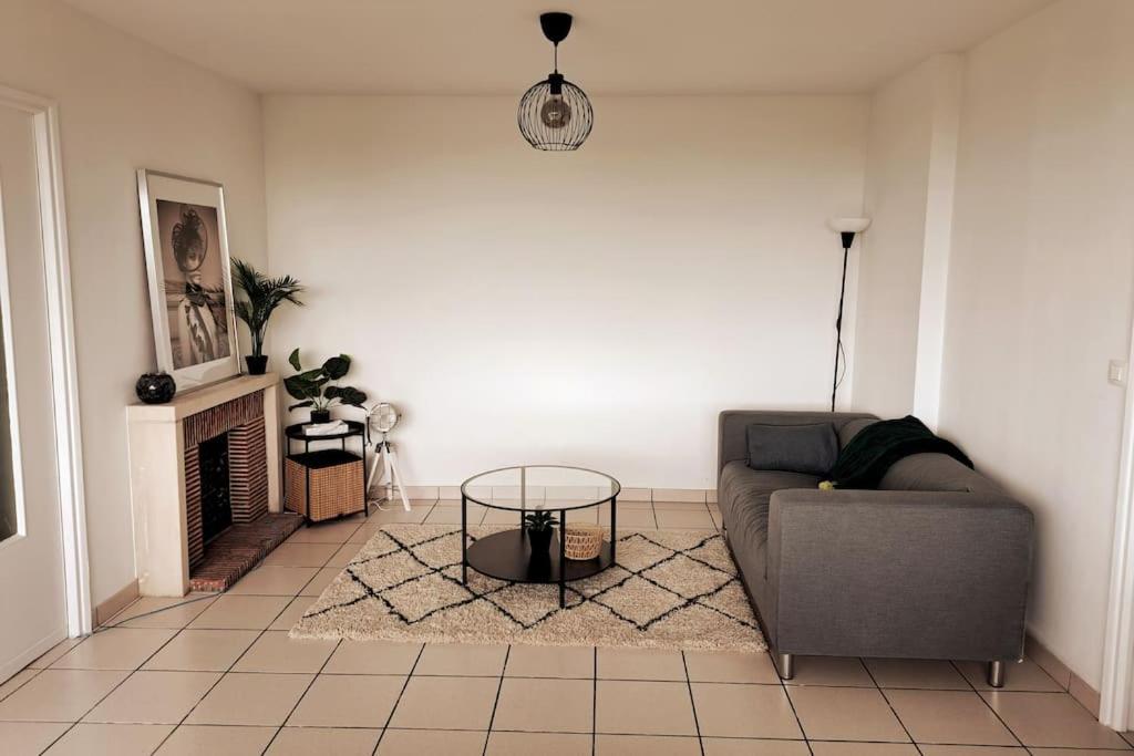 sala de estar con sofá y chimenea en Airport Access Apartment - Your Gateway to Comfort, en Charleroi