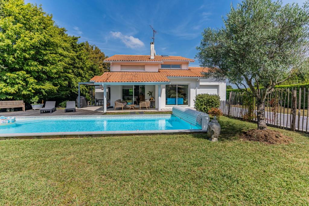 een villa met een zwembad in een tuin bij Villa St Martin in Pompignac