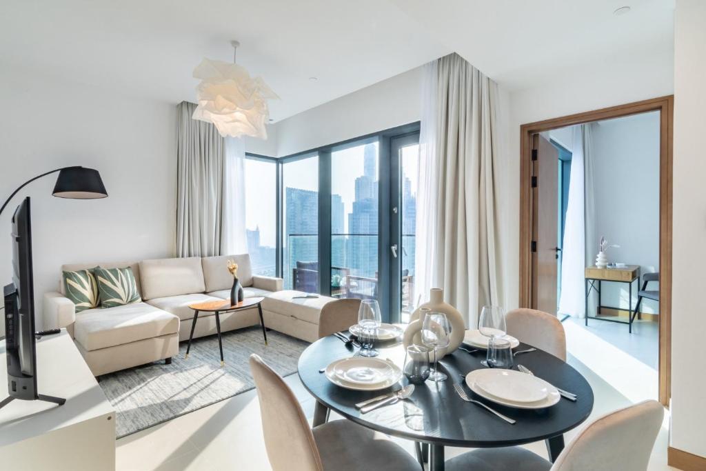 a living room with a table and a couch at Welcome Home Apartments - VIDA Marina - Full Marina view - High Floor in Dubai