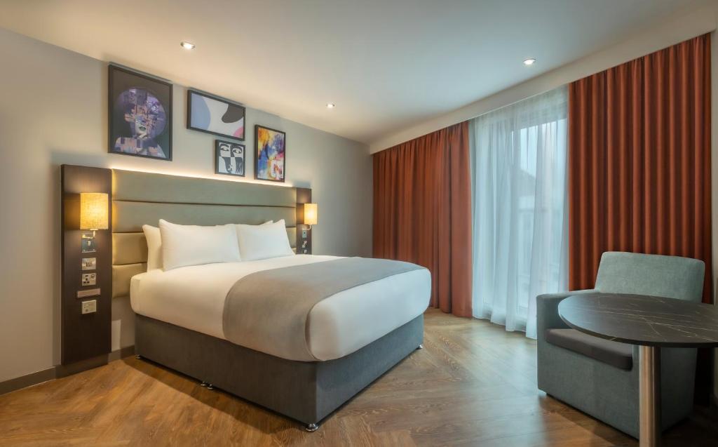 una camera con letto, tavolo e sedia di Maldron Hotel Finsbury Park, London a Londra