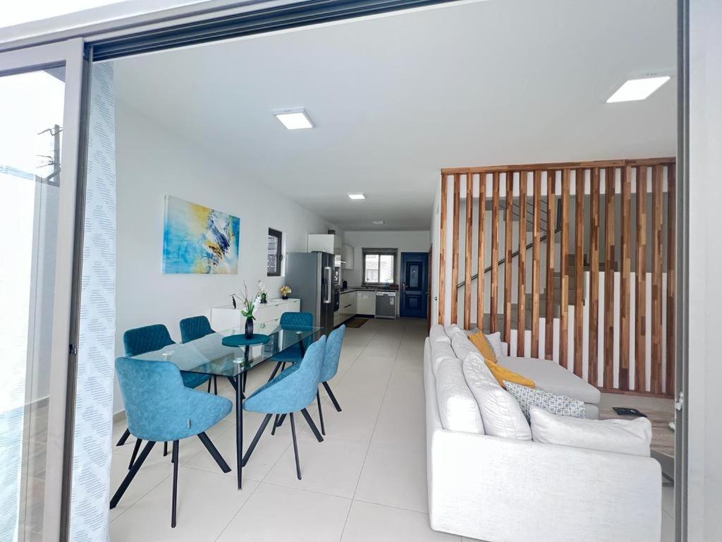 - un salon avec un canapé, une table et des chaises dans l'établissement Azure 4 Bedrooms Haven Retreat: Where Tranquility Meets Turquoise Waters, Flic en Flac Mauritius, à Flic-en-Flac