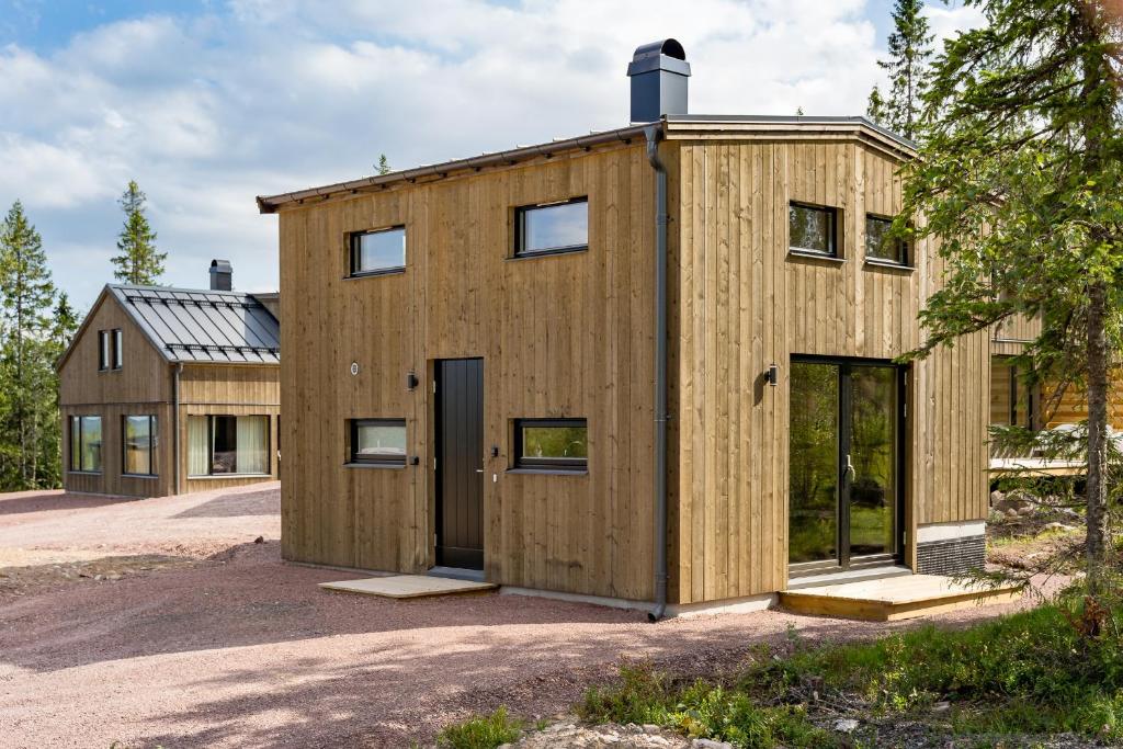 une maison en bois avec un garage dans l'établissement Mysig liten stuga perfekt för par eller liten familj, à Sälen