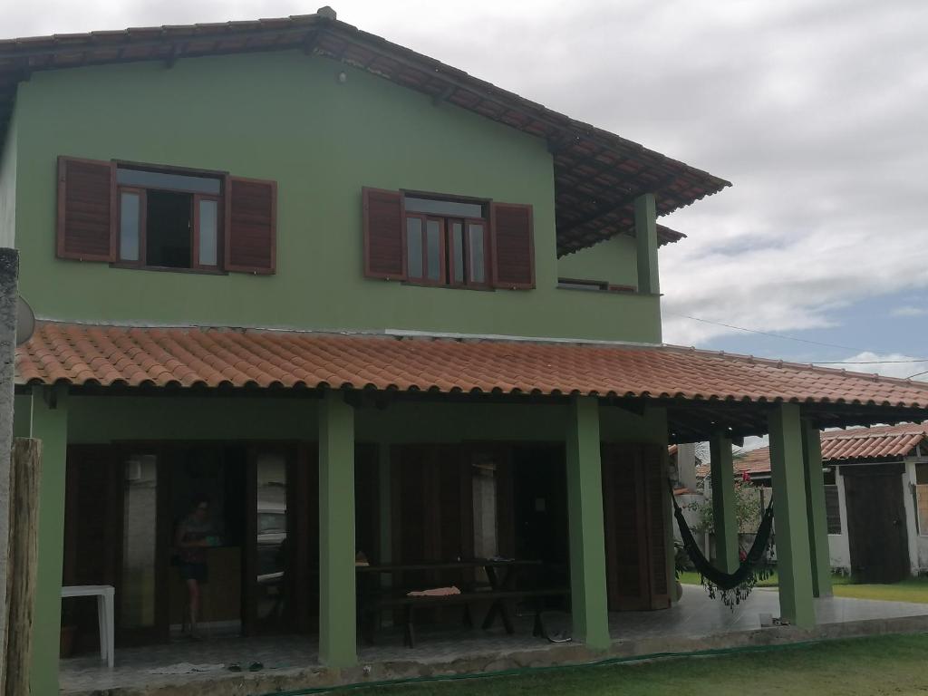 une maison verte avec un toit rouge dans l'établissement Maison de plage à Santo Antonio, à Santa Cruz Cabrália