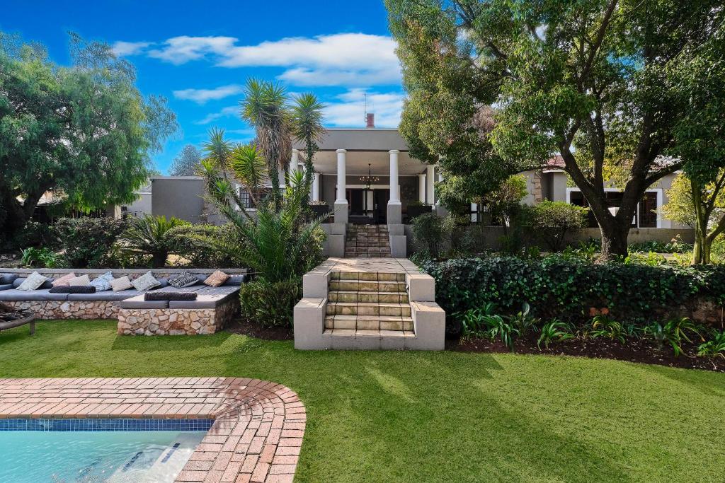 a house with a swimming pool and a yard at Rose Road Manor - Houghton Johannesburg in Johannesburg