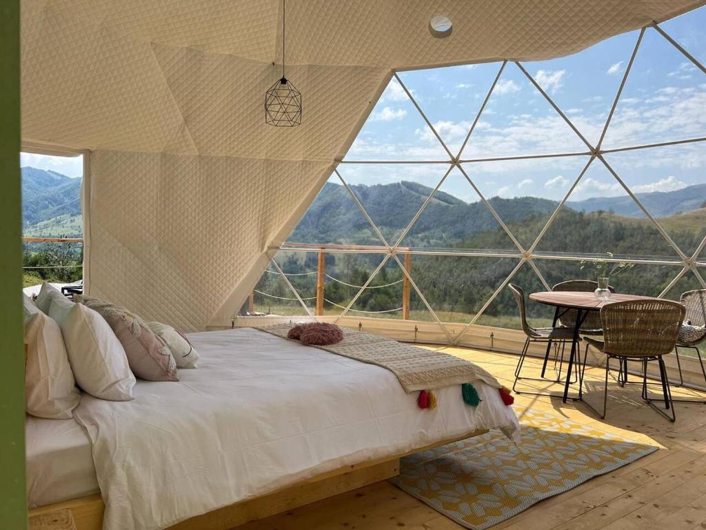 a bedroom with a bed in front of a large window at Tranquil Dome - Manta's Retreat Glamping Cornereva in Cornereva