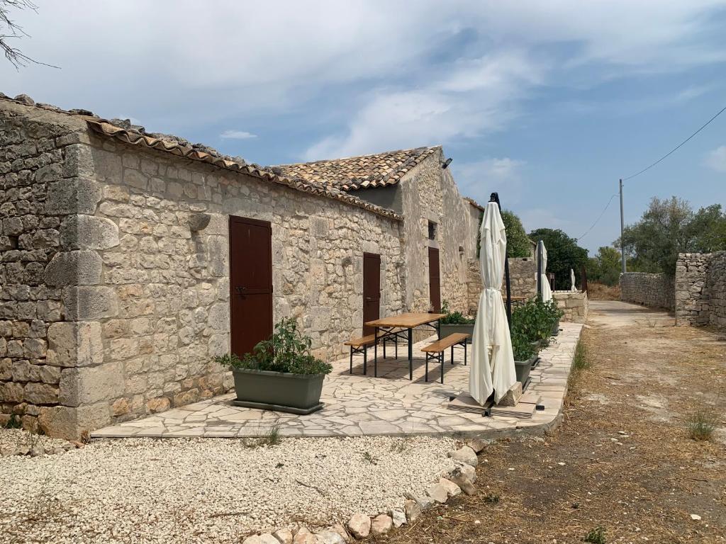Un patio con una mesa y una sombrilla y un edificio. en Casa Betta, en Módica