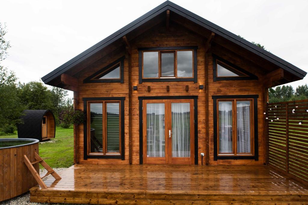 Holzhütte mit Glastüren auf einer Terrasse in der Unterkunft Saunamajutus Öötlas 