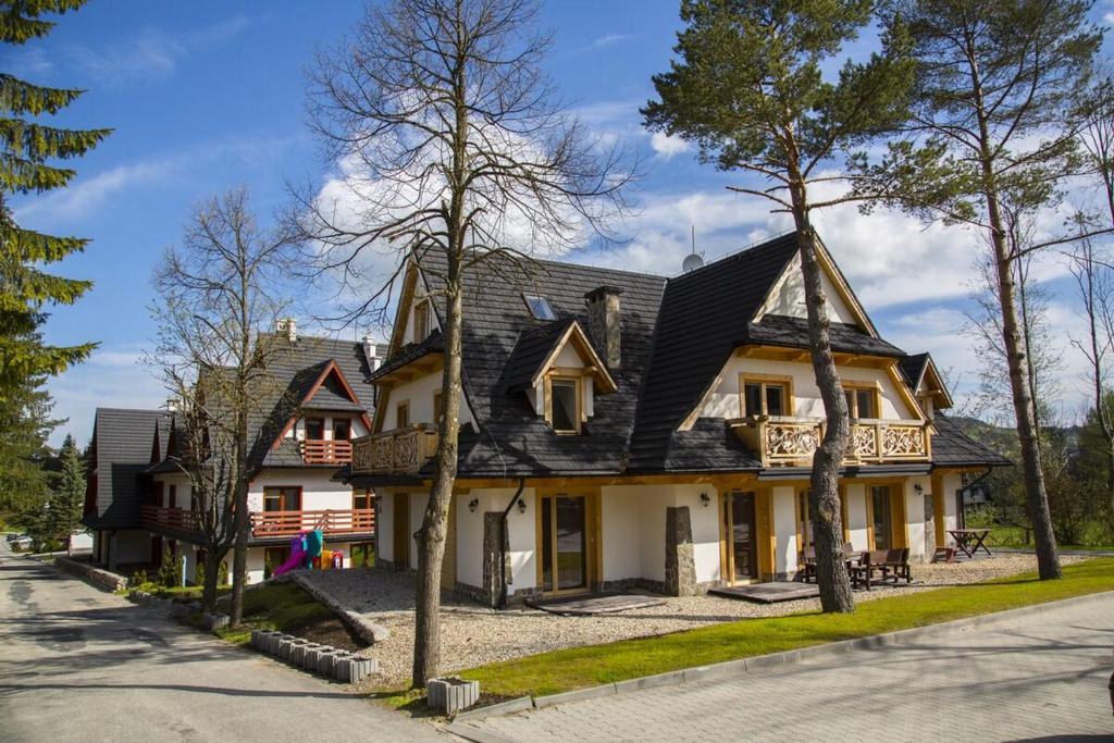 a house with a black roof at udanypobyt Apartamenty Przy Dolinach A i B in Kościelisko