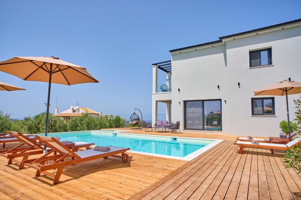 a villa with a swimming pool and a house at Olive grove villa in Plátonas