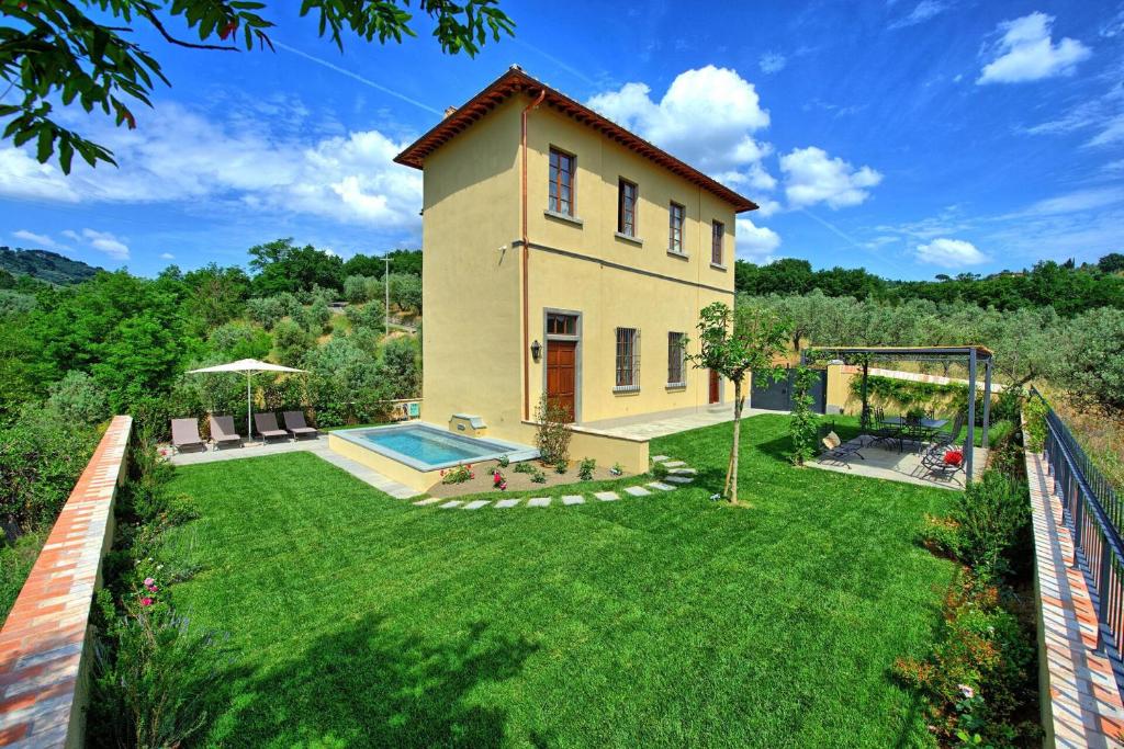 ein Haus mit einem Garten mit einem Swimmingpool in der Unterkunft Casa Lionardo by PosarelliVillas in Vinci