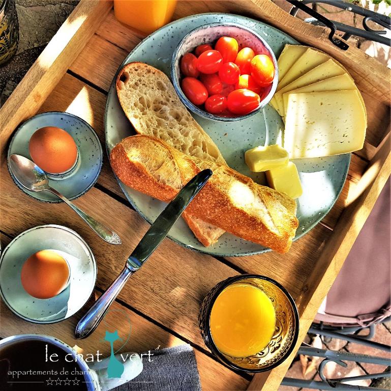 a tray of food with bread and eggs and tomatoes at Le Chat Vert - Appartements Adults Only, propreté 10 sur 10 in Saint-André