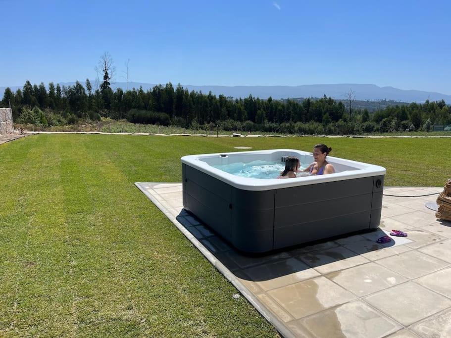 a woman and child in a hot tub in a field at Quinta do Carregal in Mangualde