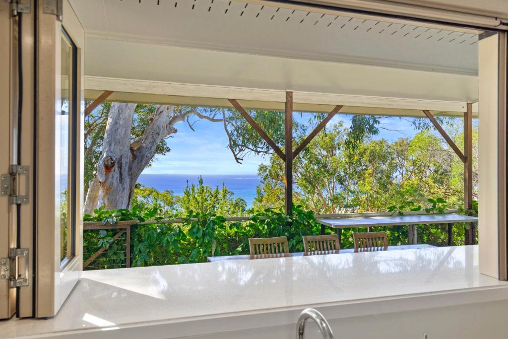 ein Bad mit einem Fenster mit Meerblick in der Unterkunft Seaspray - 93 Tramican Street in Point Lookout