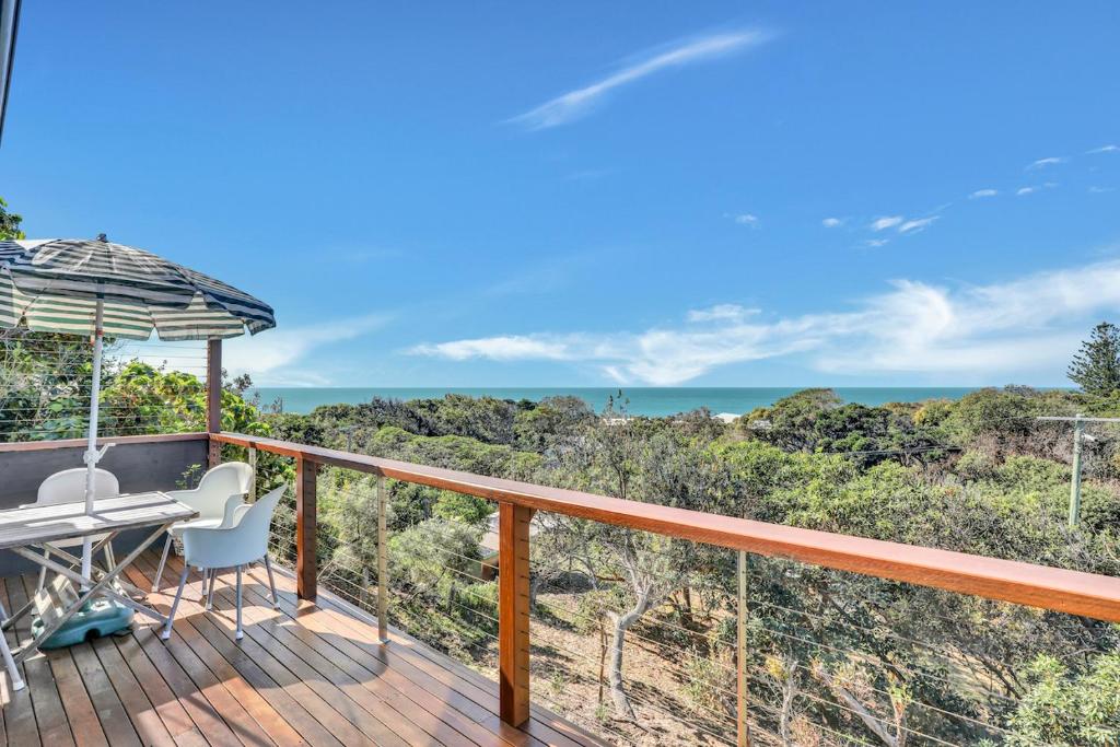 a balcony with a desk and an umbrella at Blue Waters in Point Lookout