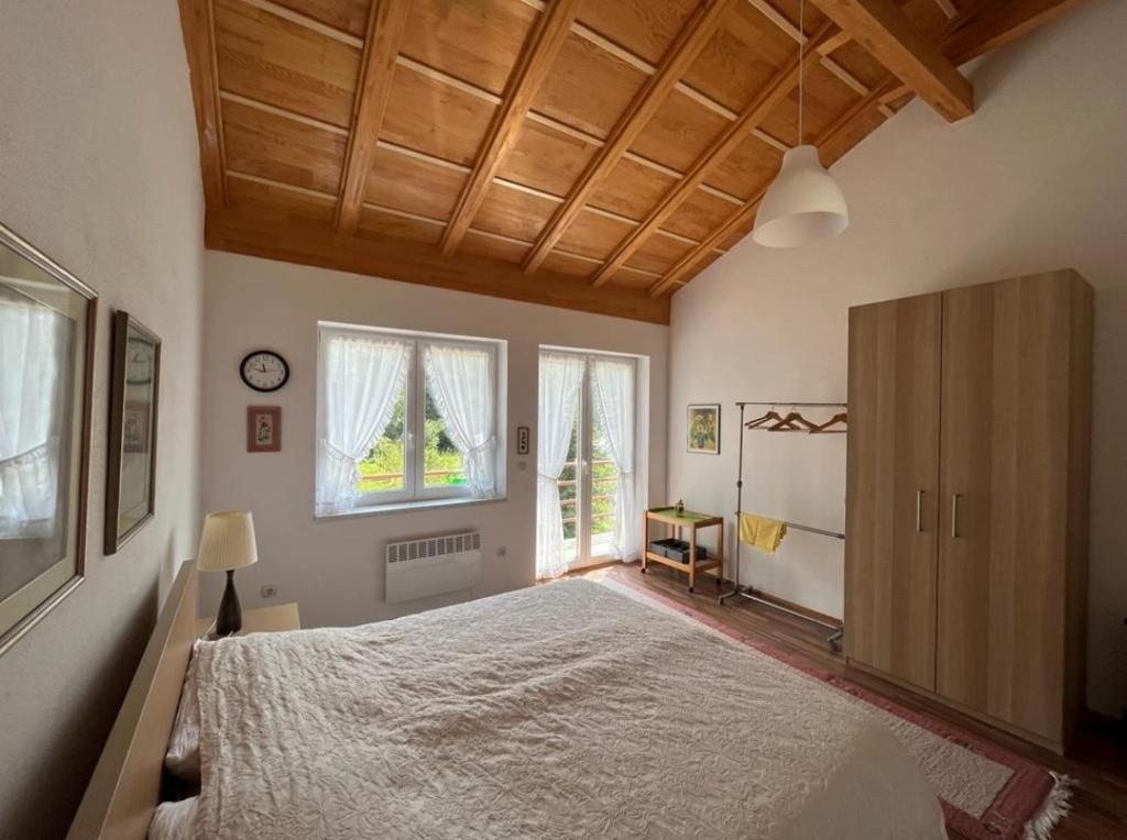 ein Schlafzimmer mit einem großen Bett und einer Holzdecke in der Unterkunft Villa Stupar 