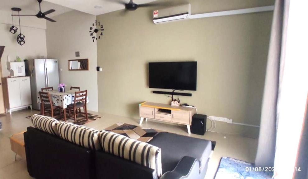 a living room with a couch and a flat screen tv at Homestay Tawau in Tawau