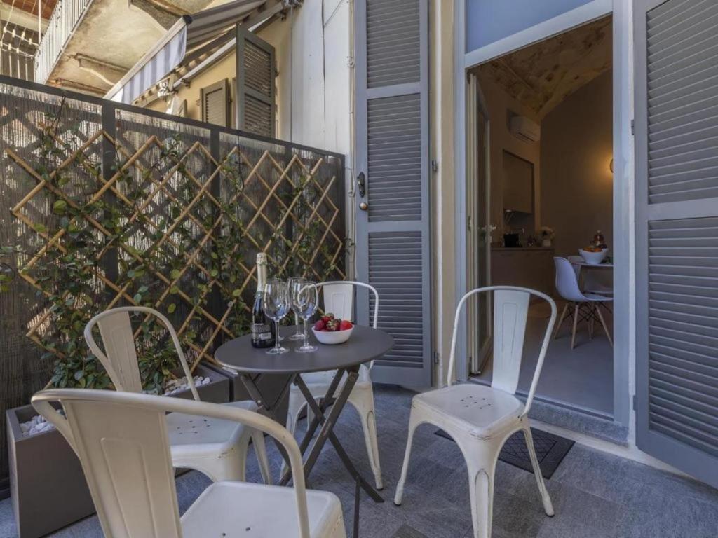 een patio met een tafel en stoelen op een balkon bij Le Tre Ca', Ca' Cecilia, Ca' Nina, Ca' Vittoria in Asti