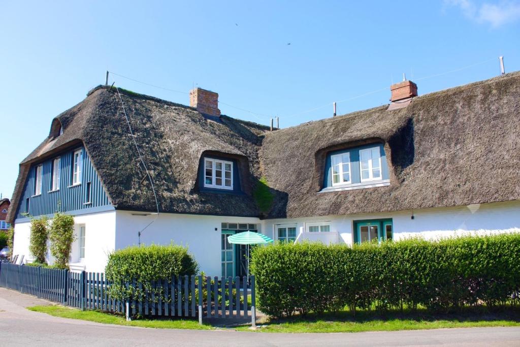 a thatch roofed house with a thatched roof at Landhaus am Meer - Whg 2 Süderaue in Utersum