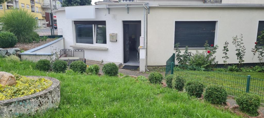 una casa con un patio con arbustos y una valla en Mobiliertes Appartement, en Bad Homburg vor der Höhe
