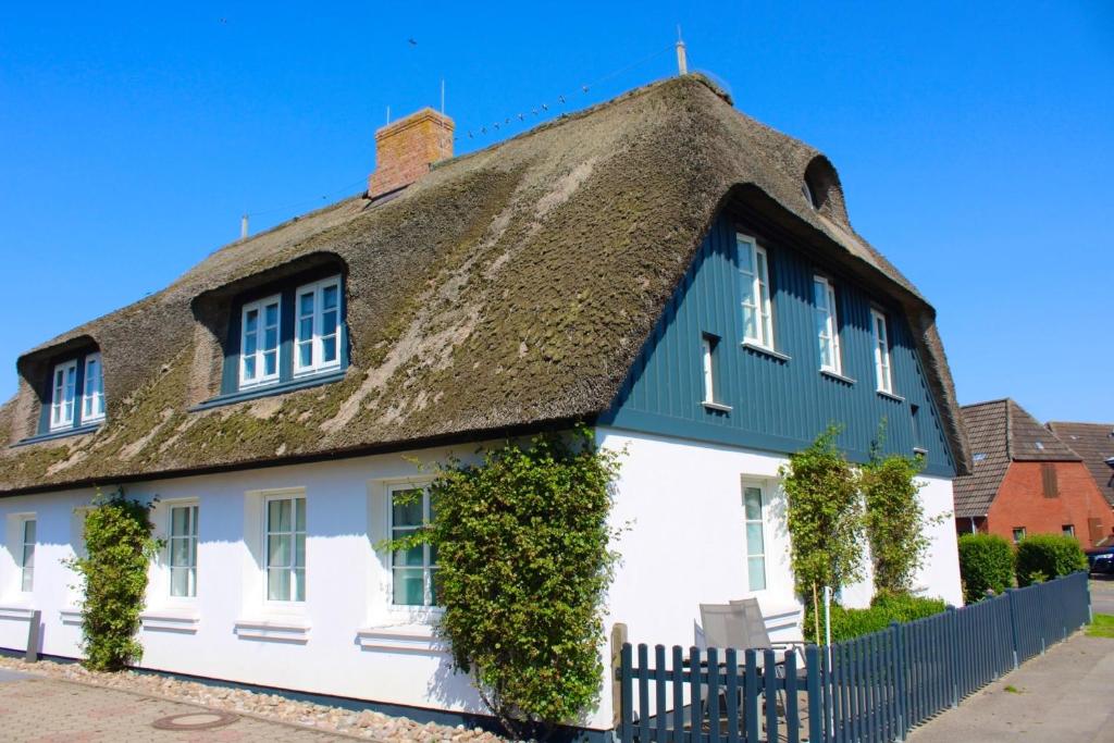 a thatched roof house with ivy at Landhaus am Meer - Whg 4 Rungholtsand in Utersum