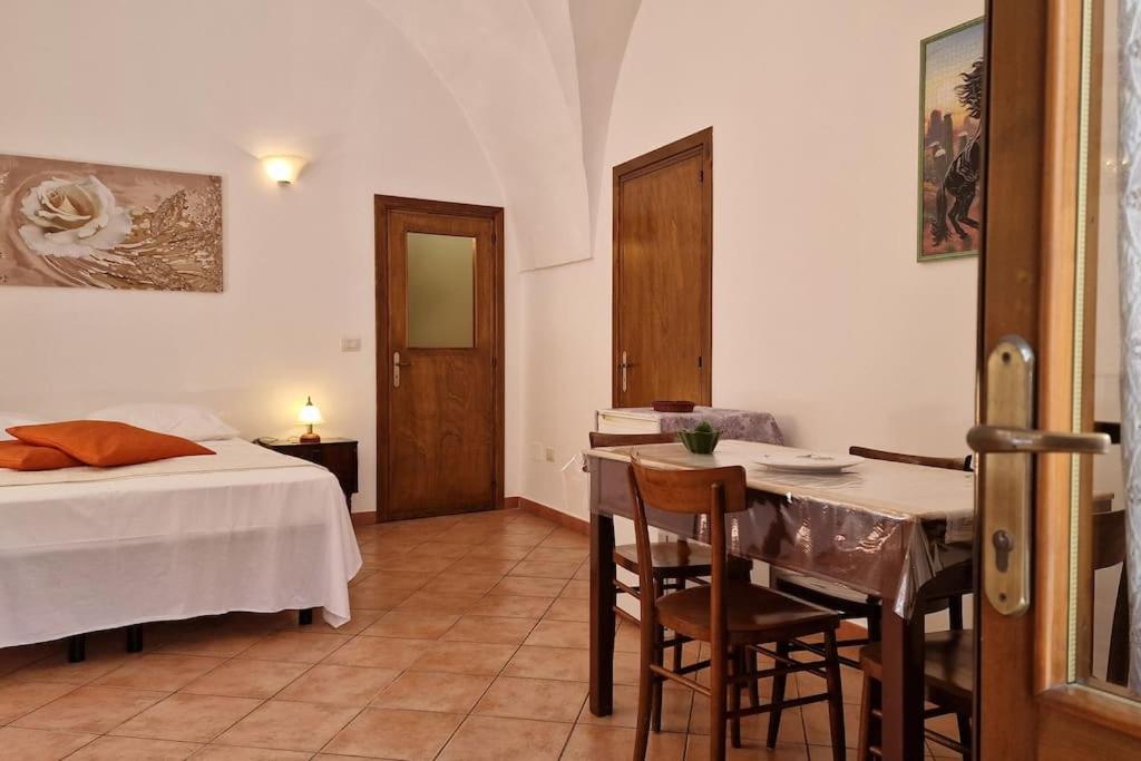 - une chambre avec un lit, une table et des chaises dans l'établissement Comodissima casa per vacanza, à Parabita