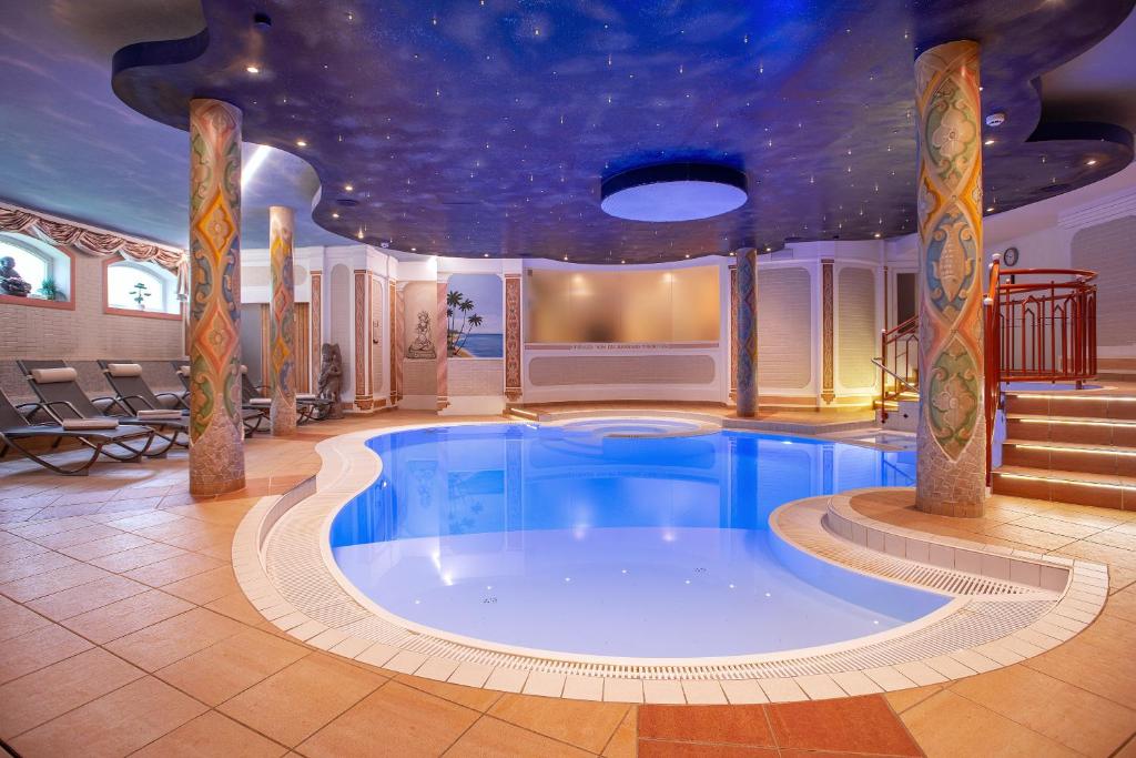 a large swimming pool in a building with a ceiling at Hotel Glockenstuhl in Gerlos