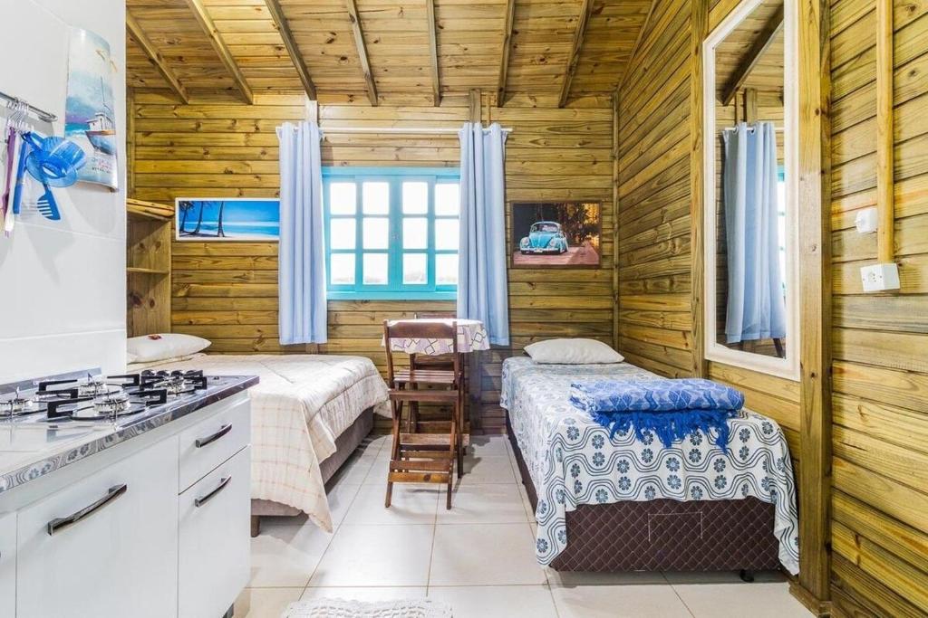 a kitchen with two beds and a stove in a room at Jajá Cabanas in Palhoça