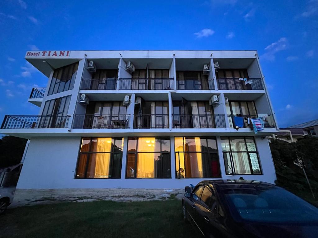 a building with a car parked in front of it at TIANI Gest House in K'obulet'i