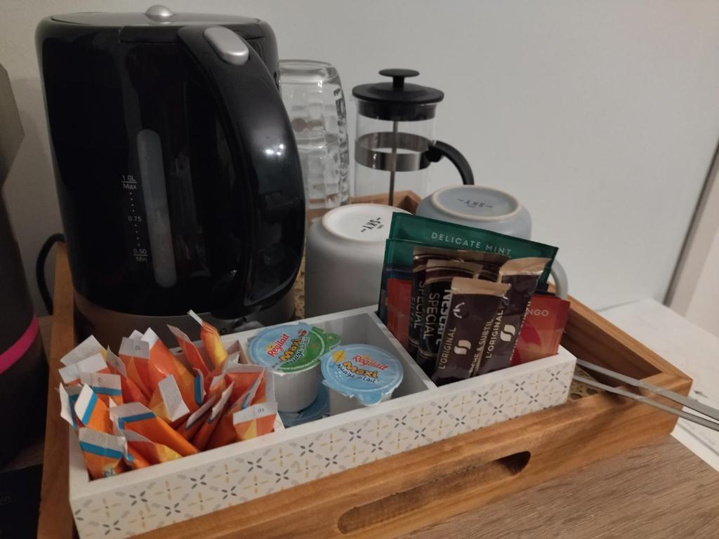 a tray filled with food and a coffee maker at Fleurs de Cosmos in Albi