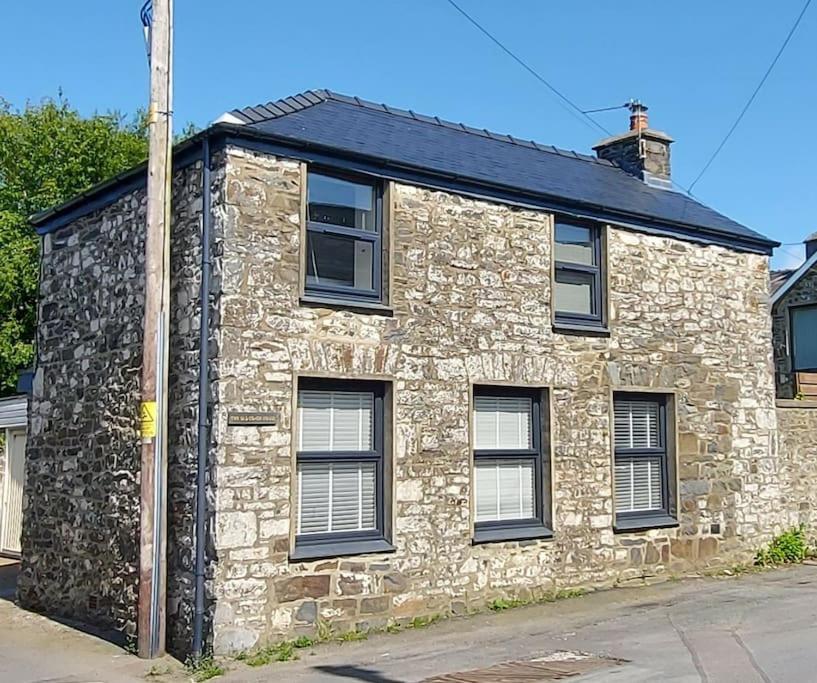 a stone building with windows and a pole at The Old Coach House in Aberaeron