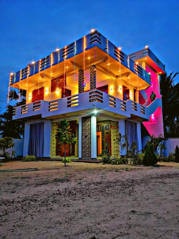 a building with lights on it on the beach at SHARAH Beach Resort in Addalachenai