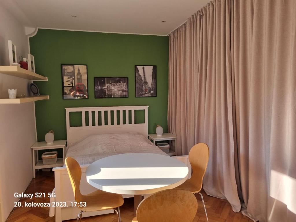 een slaapkamer met een bed en een witte tafel en stoelen bij Welcome Senj TWIN BED ! in Senj
