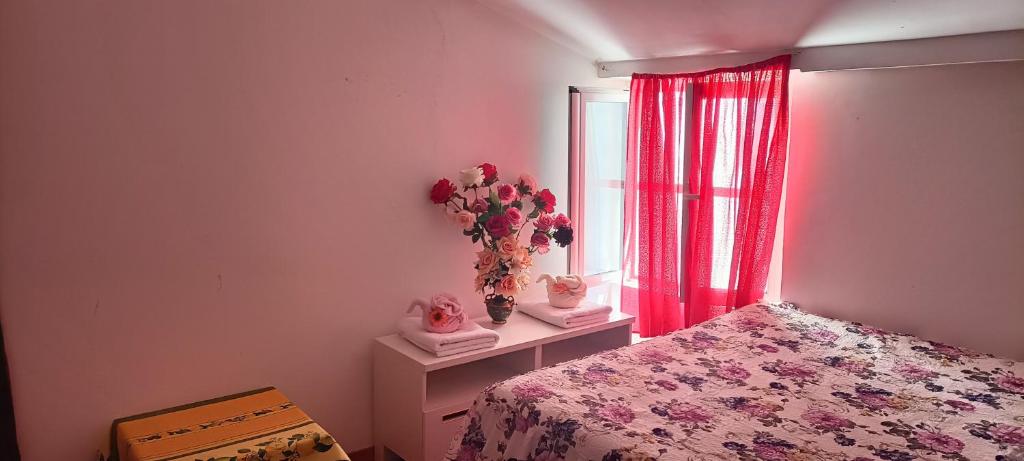 1 dormitorio con 1 cama y un jarrón de flores en SGA en Trieste