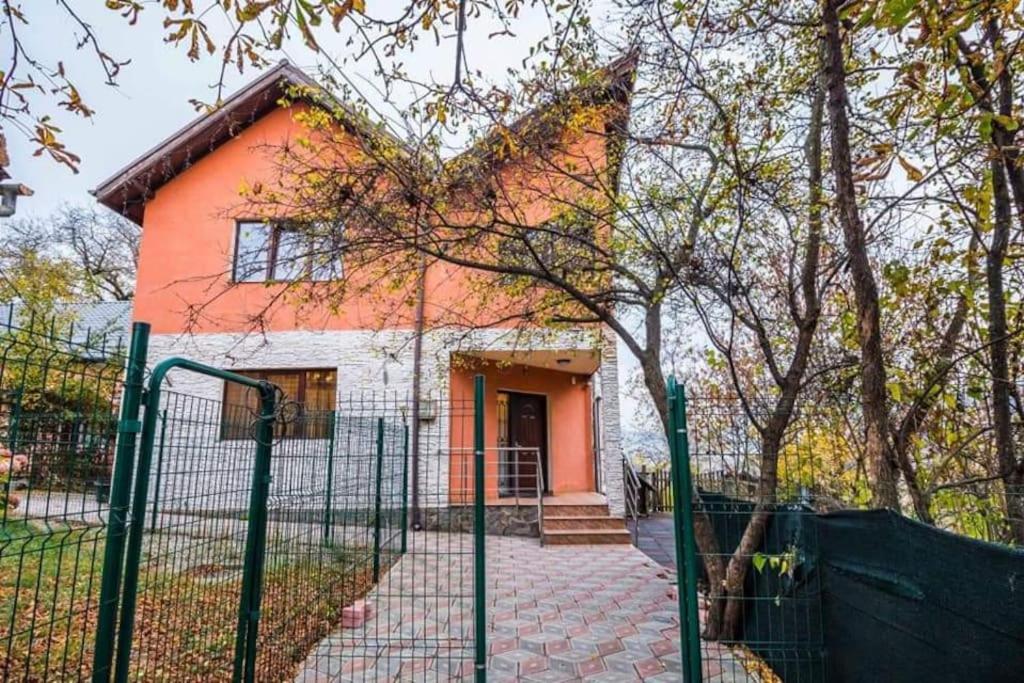 a orange house with a fence in front of it at Tampa Holiday Vila in Braşov