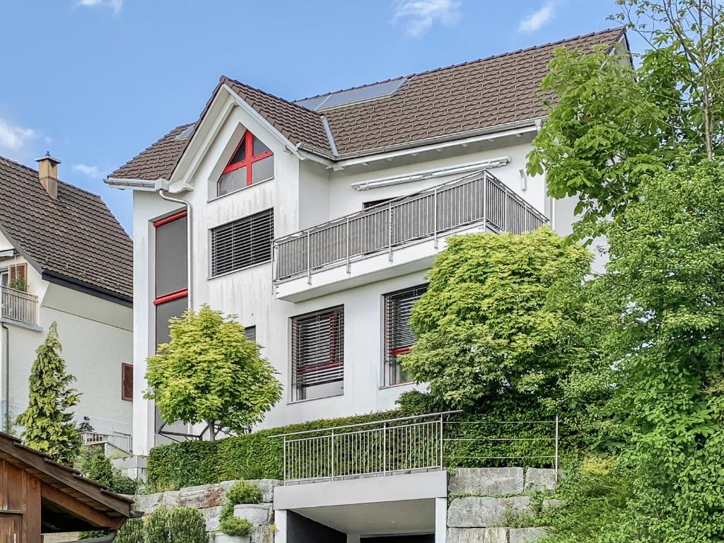 a white house with a balcony on it at Haus zur Lilie in Hinwil