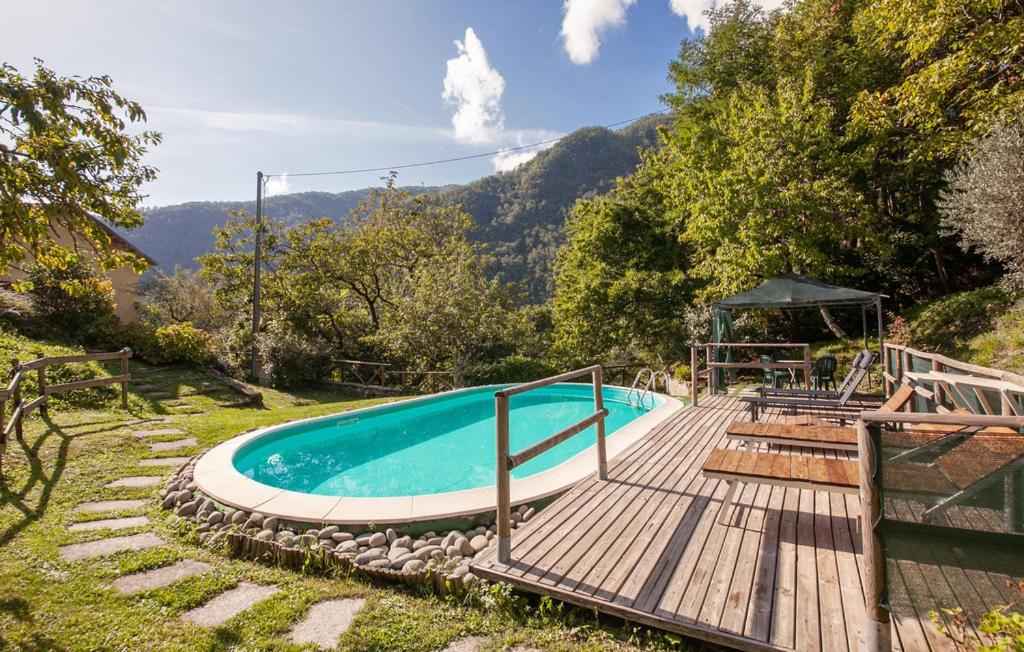 - une piscine avec une terrasse en bois à côté d'une montagne dans l'établissement Charming Le Pole in Vallico Sopra, à Bolognana
