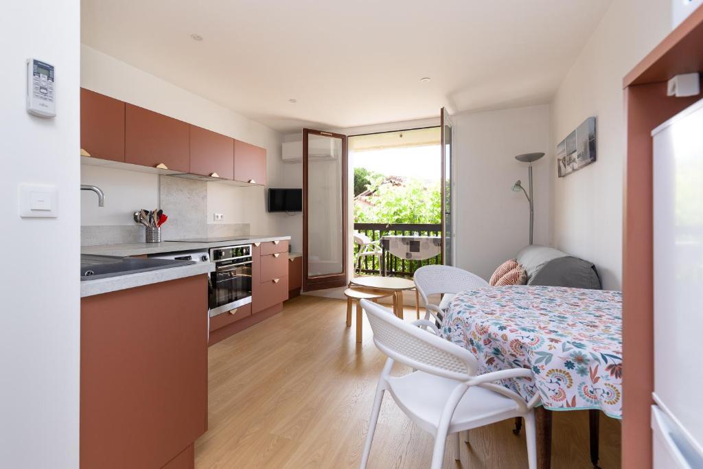 a kitchen and dining room with a table and chairs at Le Balcon du Port - Joli studio à Capbreton in Capbreton